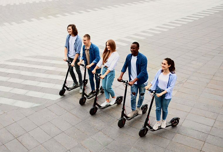 Group of university students riding electric scooters around the city