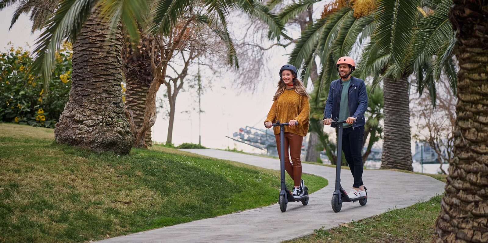 man and a woman riding a Segway Ninebot scooter in the park