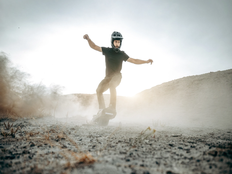 Man riding a Onewheel GT electric skateboard off road