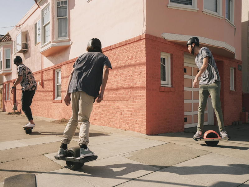 Three boys riding Onewheel electric skateboard
