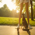 Woman and her dog rides an electric skateboard