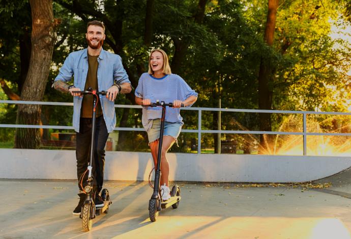 Lovely couple riding electric scooter in a park - My Electric Scooter