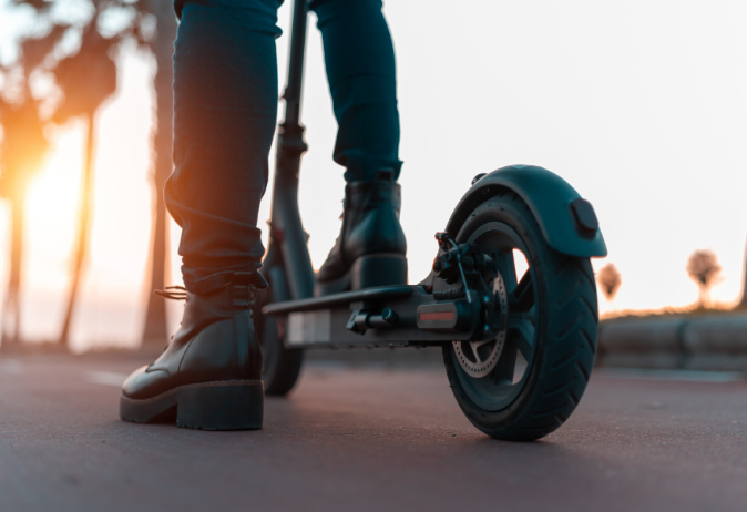 Close up image of a young woman riding an Electric Scooter during sunset - My Electric Scooter