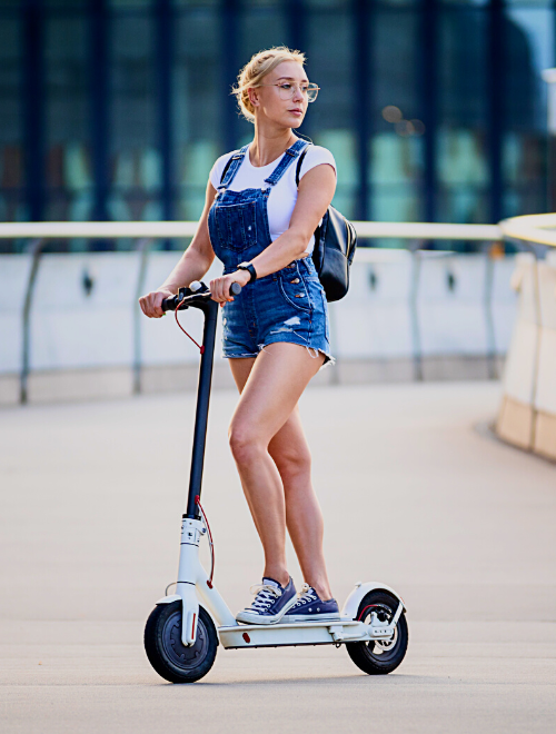 Young woman looking away while riding an electric scooter