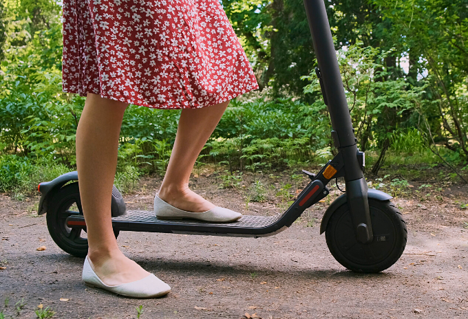 Cropped image of a woman riding an electric scooter