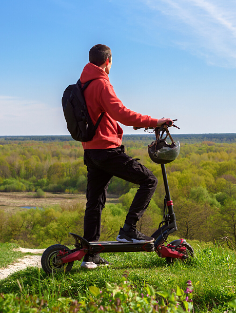 Young man riding a powerful electric scooter on a hill